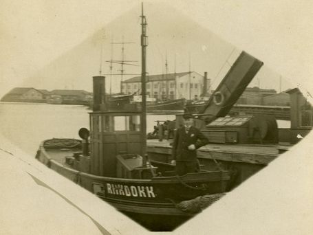 Aurupukser RIIKDOKK Tallinna sadamas. Kõrval aurukraana. Tagapool paistmas sadama hoone, mille teisel korrusel asus meremuuseum